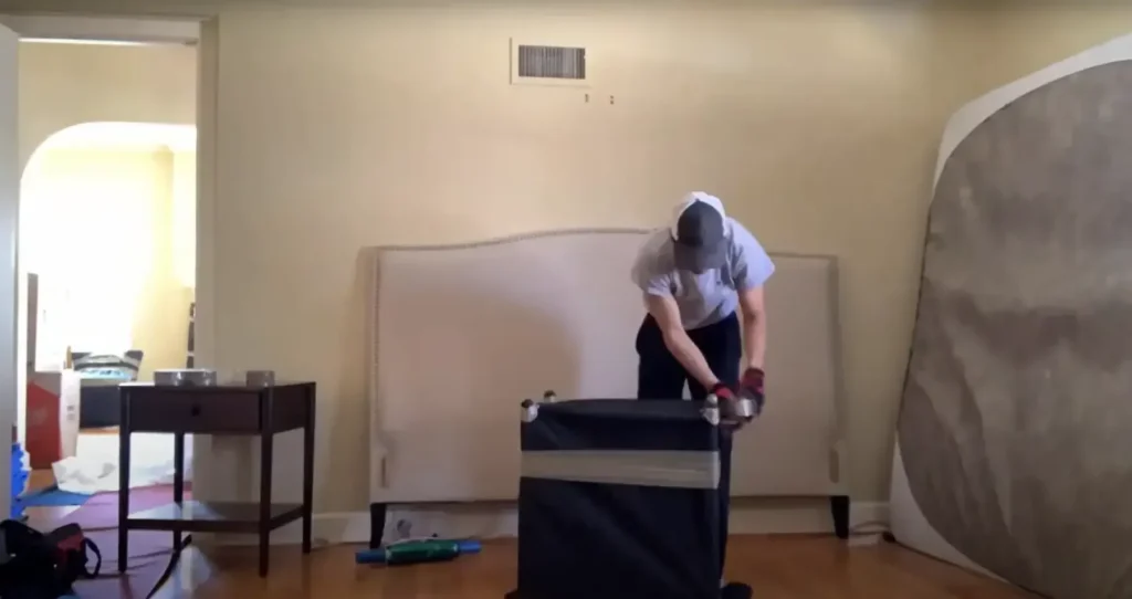 Mover packing a bedroom with the mattress against the wall