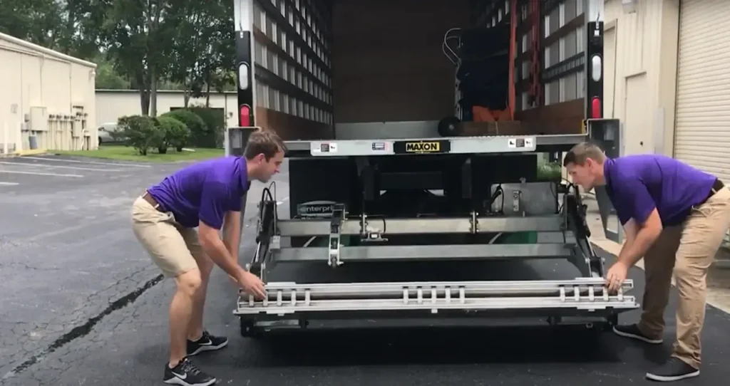 Two movers checking the truck liftgate